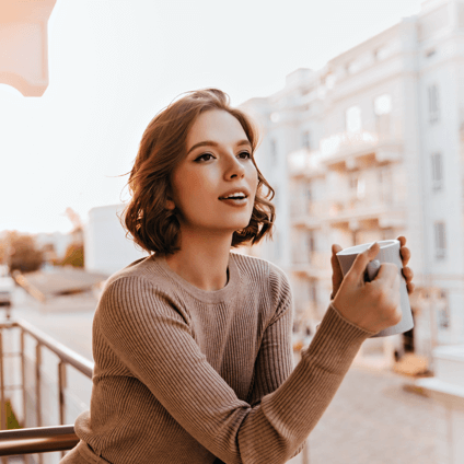 Woman enjoying a coffee on a balcony